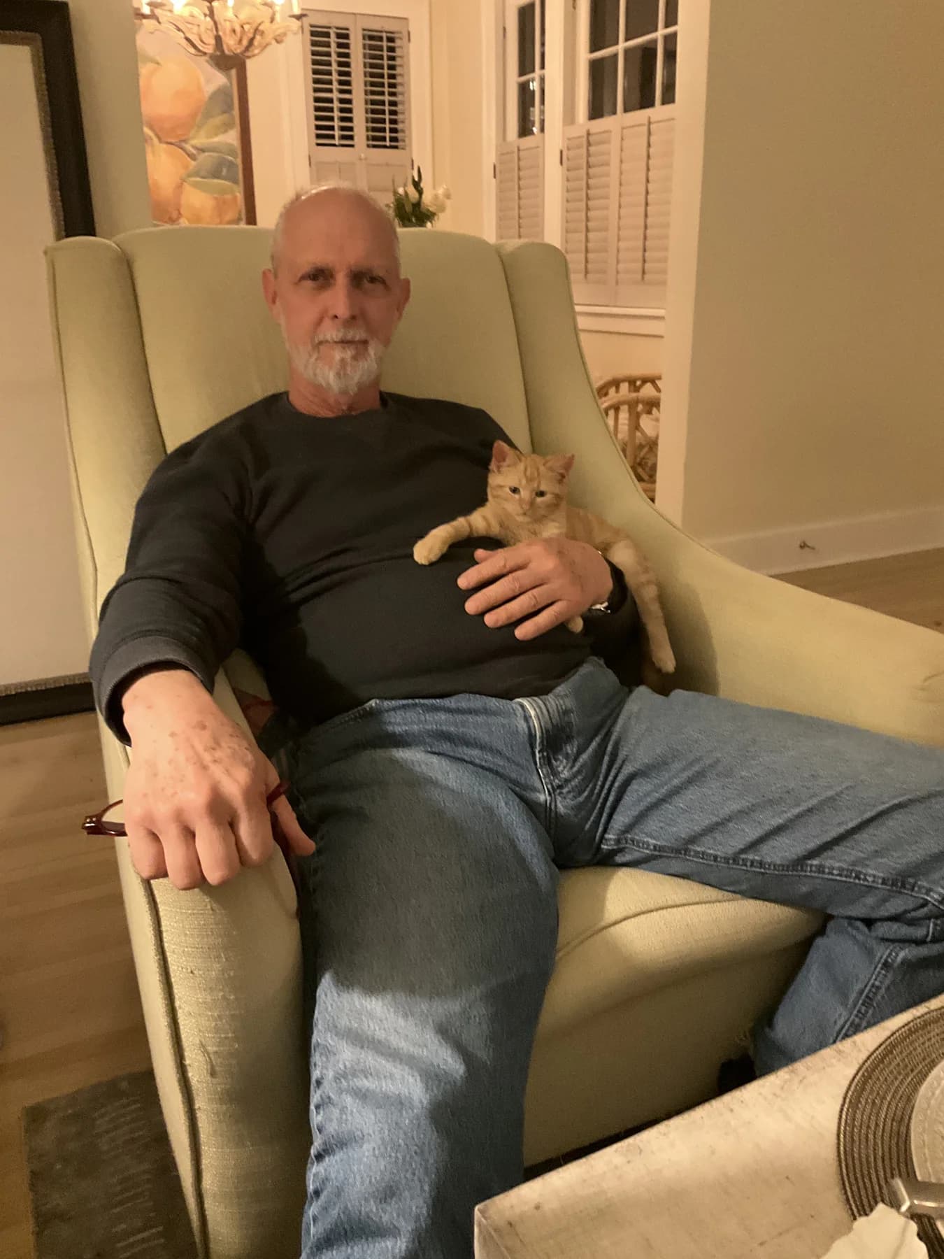 Allen Pittman at home with a cat resting on him