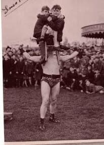Young Atlas performing a strongman feat before a crowd