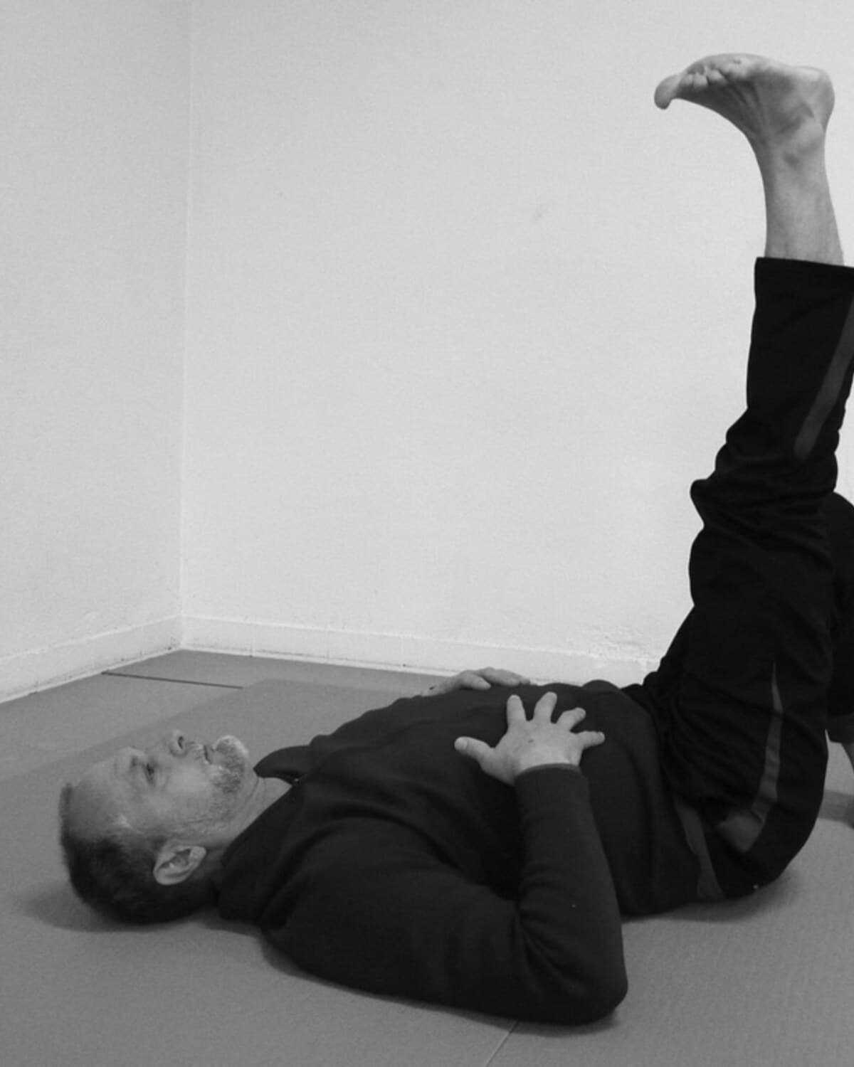Allen Pittman lying on the floor with one leg raised during a Wisdom of the Body study